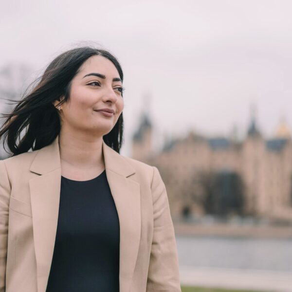 Portrait von Reem Alabali-Radovan mit dem Schweriner Schloss im Hintergrund.